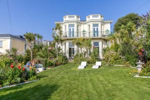 a large white house with people sitting on a lawn at The Torcroft in Torquay