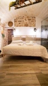 un grande letto in una stanza con muro di mattoni di Dimora Elizabeth II a Modugno