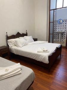 a bedroom with two beds with white sheets at Hospedaria Porto in Porto