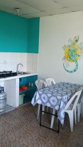 eine Küche mit einem Tisch und Stühlen sowie eine Küche mit einem Waschbecken in der Unterkunft Rancho Juancho in Portobelo