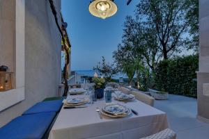 a white table with plates and silverware on a patio at Villa Rita in Makarska