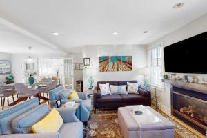 a living room with blue furniture and a flat screen tv at Beech Tree Retreat in Provincetown