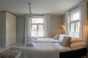 a bedroom with two beds and a window at Villa Moisio - puutaloidylliä Salon keskustassa in Salo