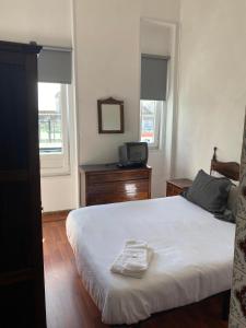 a bedroom with a bed and a tv on a dresser at Hospedaria Porto in Porto