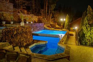 a swimming pool in a backyard at night at Safari Village Velingrad in Velingrad