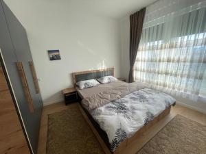 a small bedroom with a bed with a window at Your home in Prizren