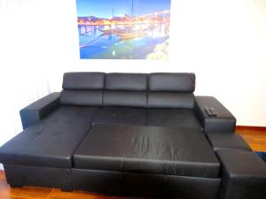 a black leather couch in a room with a painting at 5 bedrooms villa with city view private pool and jacuzzi at Porto in Porto