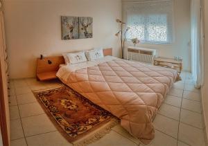 a bedroom with a large bed with a blanket at BRILLIANT HOUSE in Volos