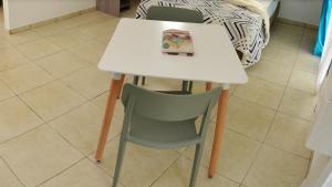 Una mesa blanca y una silla con una bolsa. en Maison d'une chambre avec vue sur la mer jardin clos et wifi a Saint Joseph, en Saint-Joseph