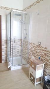 La salle de bains est pourvue d'une douche, d'un lavabo et d'une table. dans l'établissement 4 bedrooms appartement with private pool furnished terrace and wifi at Villa Campanile, à Orentano