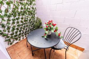 una mesa con un jarrón de flores y una silla en Hospedaxe Memorias de Sophia, en Finisterre