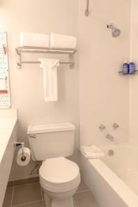 Wildwood Snowmass في سنوماس فيليج: حمام ابيض مع مرحاض وحوض استحمام