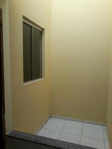 a empty room with a window and a tiled floor at Hospedagem Petrolina in Petrolina