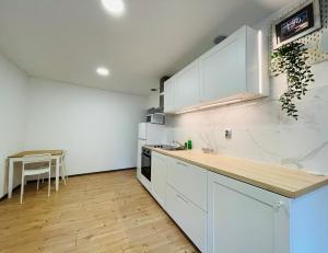 a kitchen with white cabinets and a wooden floor at Red app by Alex Rafel, close to the bus station in Zagreb