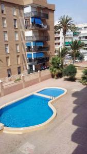 a large blue swimming pool in front of a building at 2 bedrooms apartement with sea view shared pool and furnished balcony at Aguilas in Águilas