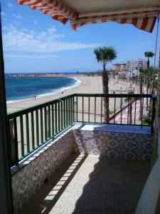 a balcony with a view of a beach and the ocean at 2 bedrooms apartement with sea view shared pool and furnished balcony at Aguilas in Águilas