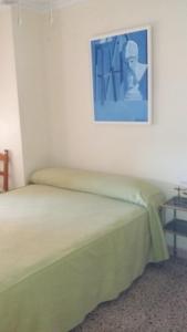 a bedroom with a bed and a painting on the wall at 2 bedrooms apartement with sea view shared pool and furnished balcony at Aguilas in Águilas