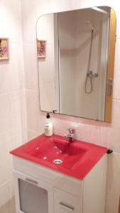 a red sink in a bathroom with a mirror at Apartment with pool in Águilas 75 m² with sea view in Águilas