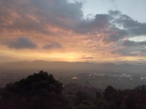 uma vista para o pôr-do-sol a partir de uma montanha em La Casita de Chocolate 3 em Bogotá