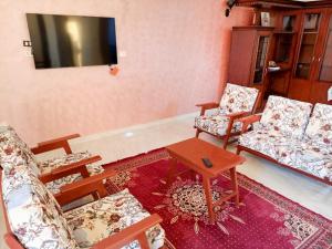 salon z krzesłami i telewizorem z płaskim ekranem w obiekcie Panoramic Apartment looks over Nile river w mieście Aswan