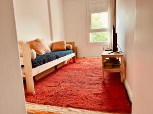 a living room with a couch and a red rug at Live it up Marvila in Lisbon