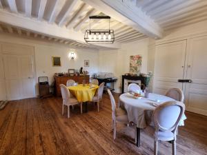 una sala da pranzo con due tavoli e sedie bianche di LE MANOIR- CLUNY a Cluny
