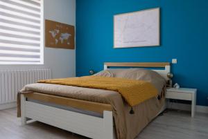a bedroom with a bed with a blue wall at Kerfloreve in Plouescat