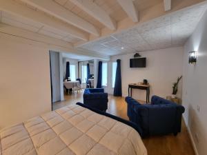 a bedroom with a bed and two blue chairs at LE MANOIR- CLUNY in Cluny