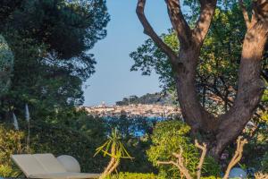 a white couch sitting next to a tree at Les Capucines Saint Tropez in Saint-Tropez