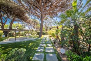 a garden with trees and a pathway at Les Capucines Saint Tropez in Saint-Tropez