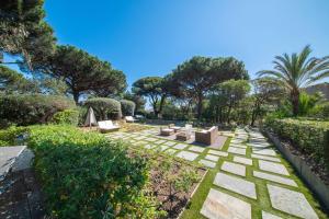 a garden with couches and trees and grass at Les Capucines Saint Tropez in Saint-Tropez