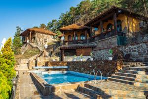 a house with a swimming pool on a mountain at Safari Village Velingrad in Velingrad