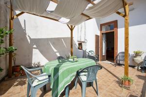 a table with a green table cloth on a patio at 4 bedrooms apartement with furnished terrace and wifi at Cava de' Tirreni 3 km away from the beach in Cava deʼ Tirreni