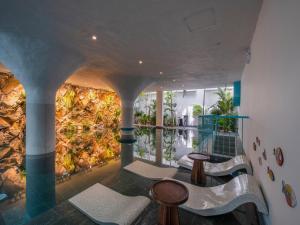 een kamer met stoelen en een muur met planten bij Le Bouton Smart Boutique Hotel in Da Nang