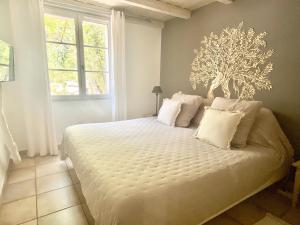 オービニャンにあるLe Jardin de Lauのベッドルーム(白い枕の大型ベッド1台付)