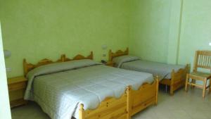 - une chambre avec 2 lits jumeaux et une chaise dans l'établissement Albergo Nazionale, à San Giacomo