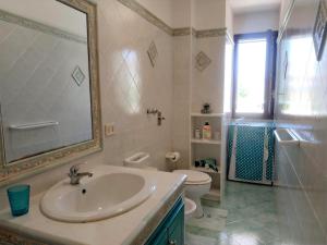 La salle de bains est pourvue d'un lavabo, de toilettes et d'un miroir. dans l'établissement MARGIC, à San Vito Lo Capo