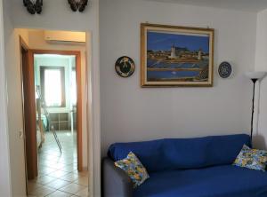 a blue couch in a living room with a picture on the wall at MARGIC in San Vito lo Capo