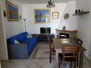 ein Wohnzimmer mit einem blauen Sofa und einem Tisch in der Unterkunft MARGIC in San Vito lo Capo