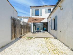 patio z parasolem obok budynku w obiekcie Maison Angoulins: 6 Pers, Mer à 150m, WIFI, Terrasse, Équipée Bébé - FR-1-535-45 w mieście Angoulins