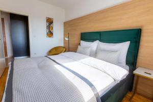 Schlafzimmer mit einem großen Bett mit einem grünen Kopfteil in der Unterkunft Platinum_Luxury_Apartment in Teslić
