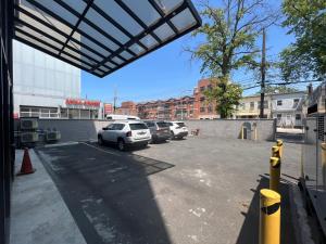 a parking lot with several cars parked in it at Flushing Garden Hotel in Queens