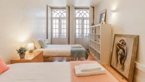 1 dormitorio con 2 camas y estante para libros en Porto 61 - Bright 2BR w/ Balcony by LovelyStay, en Oporto