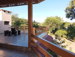 a patio with a table and chairs on a deck at Hospedagem na cidade das flores in Pareci Novo