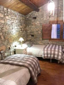 um quarto com 2 camas e uma parede de pedra em 2 bedrooms house with furnished garden at Las Colladas em Las Colladas