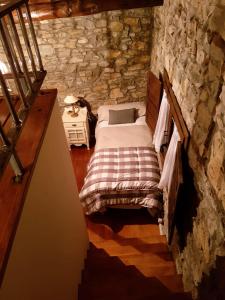 1 dormitorio con 1 cama en una pared de piedra en 2 bedrooms house with furnished garden at Las Colladas, en Las Colladas