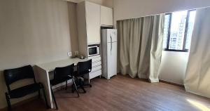 a kitchen with a table and chairs and a refrigerator at Flat R Borges Lagoa Ibirapuera c/ garagem UH1005 in Sao Paulo