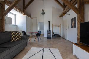 a living room with a couch and a stove at Apartmán v lokalitě statku ve Vrhavči in Vrhaveč