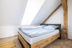 a bed with a wooden frame in a room at Apartmán v lokalitě statku ve Vrhavči in Vrhaveč