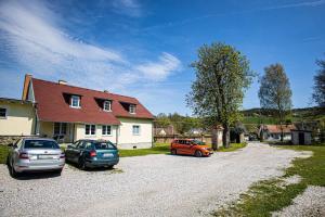 three cars parked on a gravel road in front of a house at Apartmán v lokalitě statku ve Vrhavči in Vrhaveč